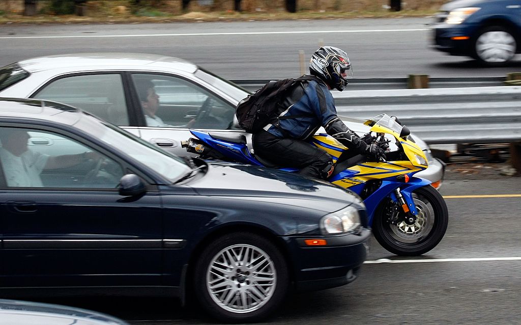File - A motorcyclist rides between cars in slow moving traffic on Highway 101 October 16, 2007 in ...