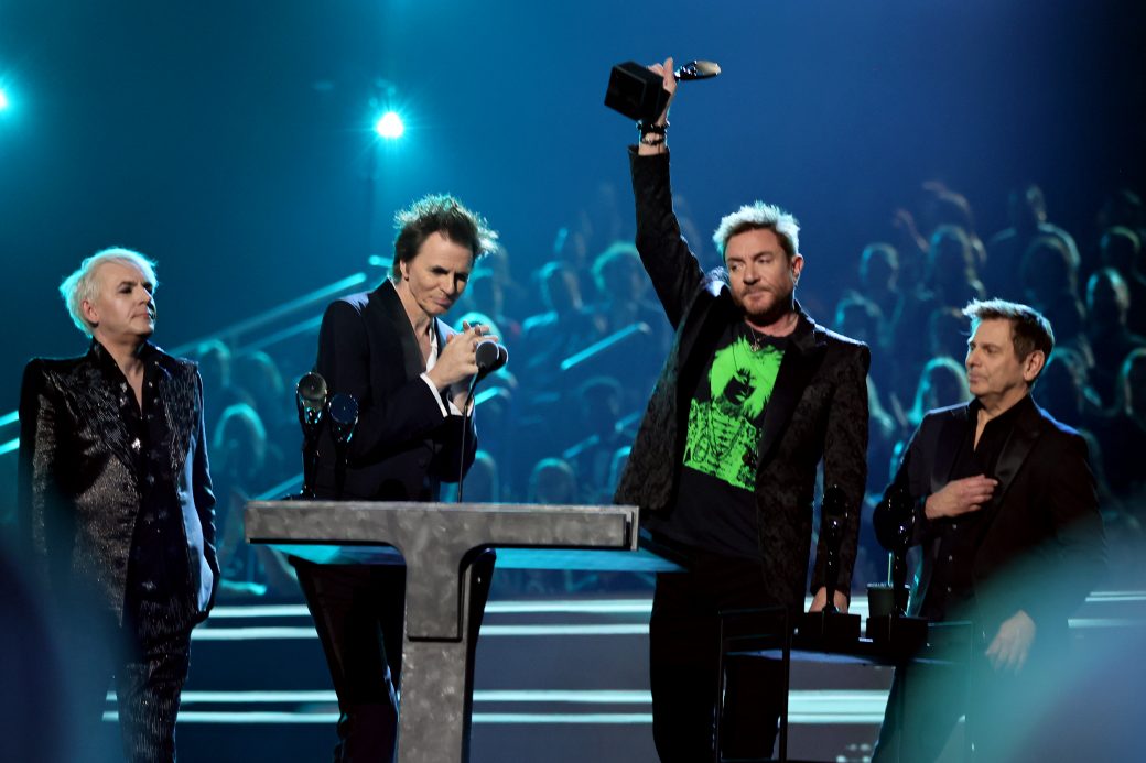 4 members of duran duran accept the trophy for Rock and Roll Hall of Fame at the podium
