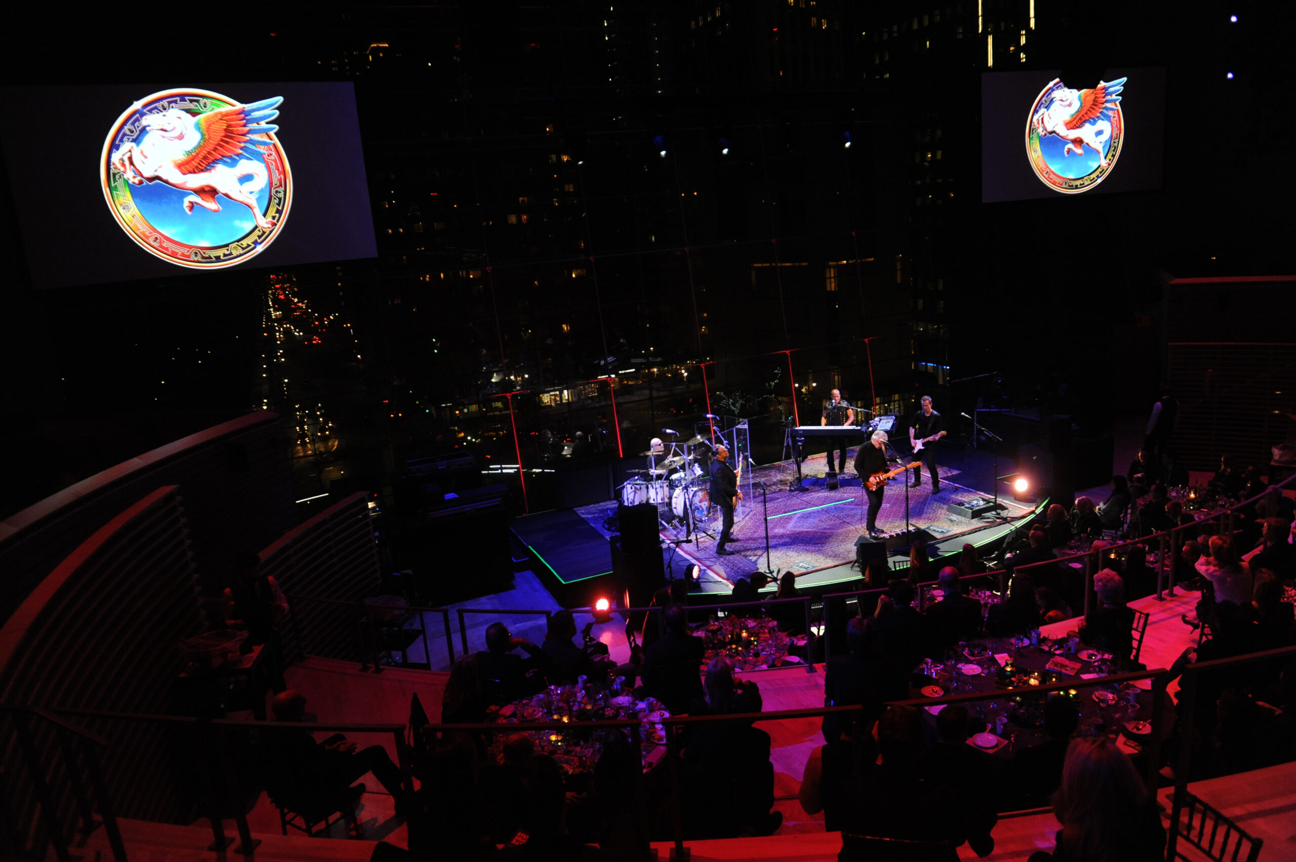 far out view of steve miller band performing with their logos of the flying eagle